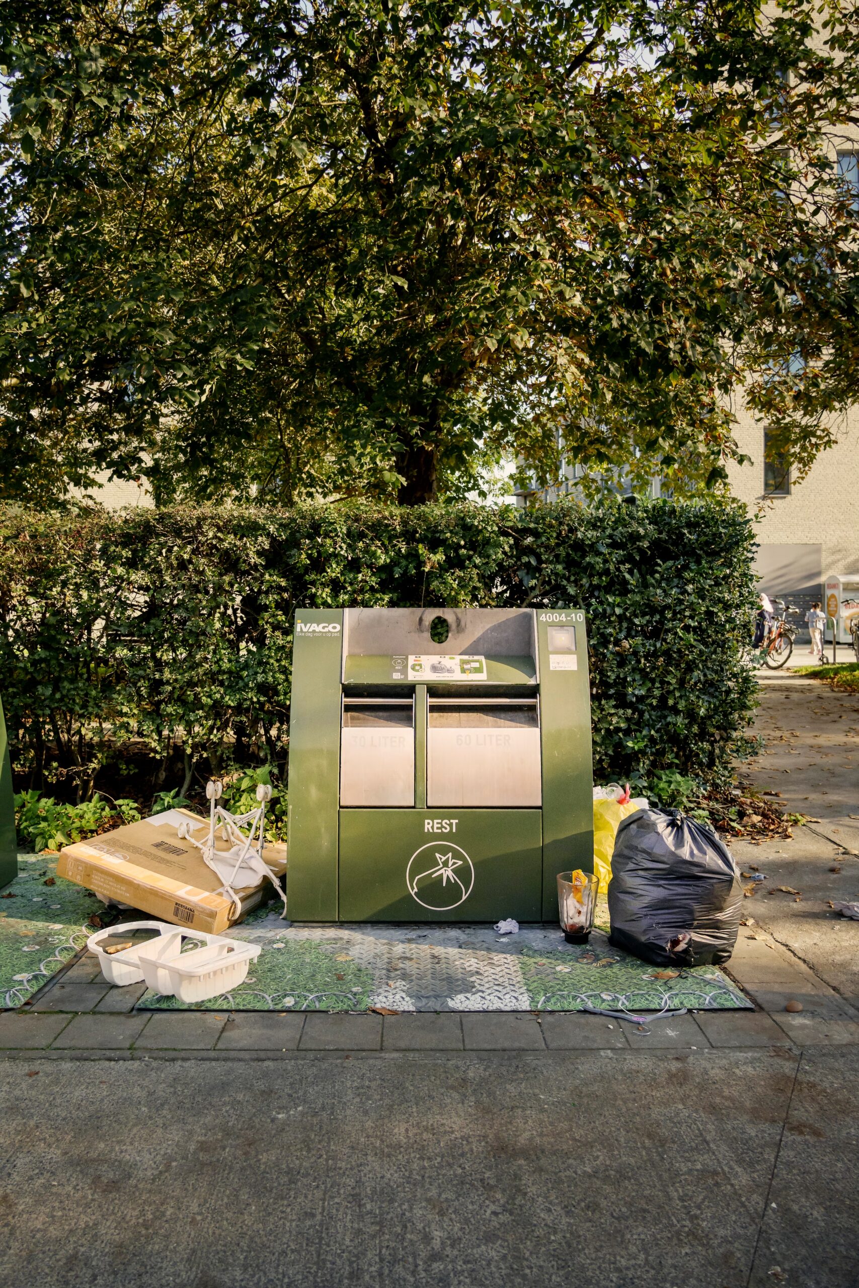 Restvuilbak in Gent met ernaast heel wat zwerfvuil.